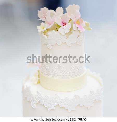 Delicious original white wedding cake decorated with flowers