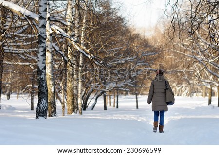 Beautiful woman walking in winter park