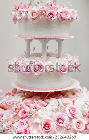 Delicious white wedding cake decorated with pink cream roses