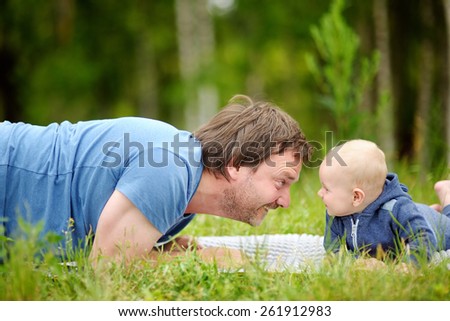 Happy middle age man playing with his little baby