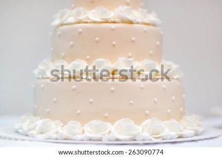 Delicious peach and white wedding cake decorated with cream roses