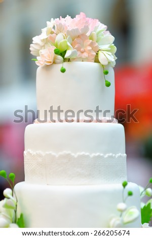 White wedding cake decorated with cream flowers