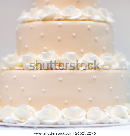 Delicious peach and white wedding cake decorated with cream roses
