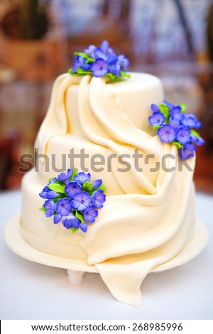 Delicious white wedding or birthday cake decorated with flowers