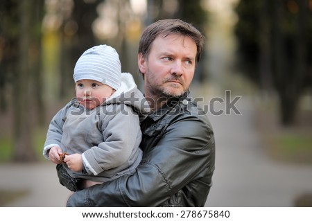 Middle age father with his toddler son walking outdoors / kidnapping concept