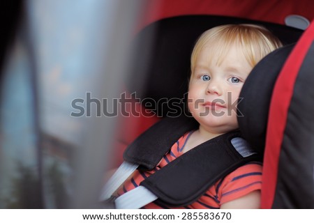 Beautiful toddler boy sitting in car seat