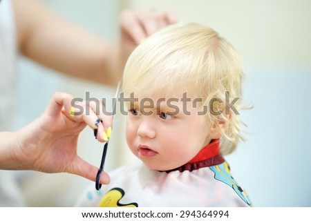 Toddler child getting his first haircut