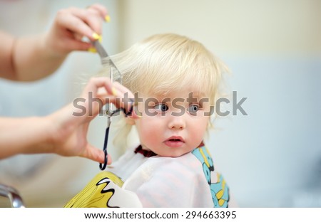 Toddler child getting his first haircut