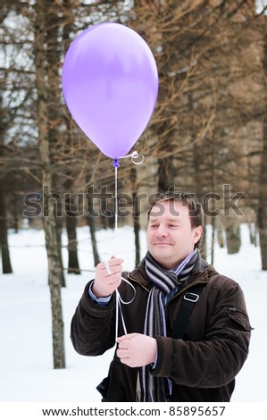 A man holding purple balloon