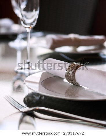A dining table scene with focus on the napkin ring with plenty of copy space.