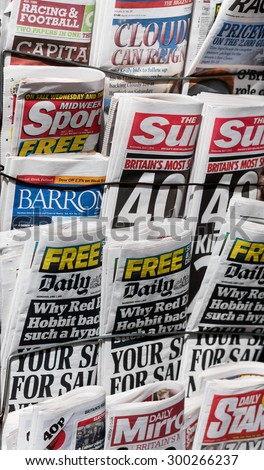 LONDON, UNITED KINGDOM- 1 APRIL 2015: Famous British tabloids on a rack including The Mirror, Barrons, Daily star, The Independent, The Sun, Daily Mail, Midweek Sport and Racing and Football Outlook.