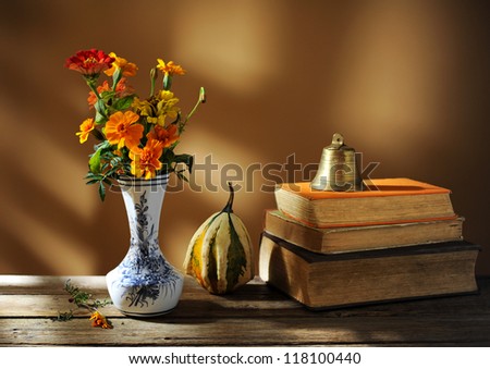 Old books, decorative pumpkins and flowers