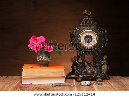 Flowers, books and clock on the table