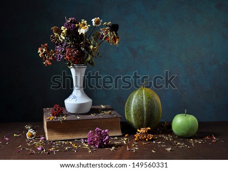 Dried flowers in a vase and books on the table