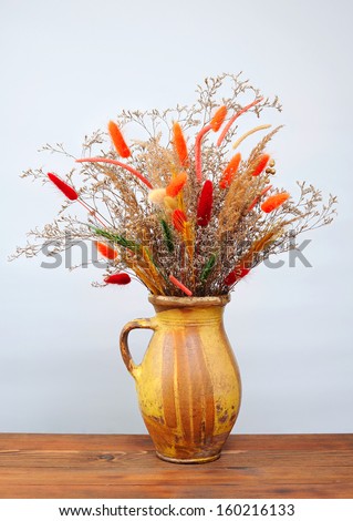 Dried flowers in a ceramic vase on the table