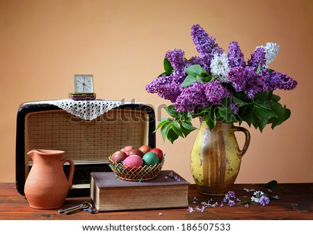 Lilac in a vase, old radio and easter eggs on the table