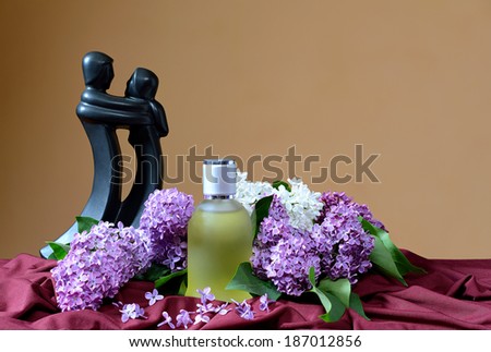 Lilac and perfume in glass bottle on the table