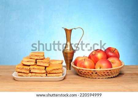 Apple cake, a metal carafe and fruit in a basket on the table