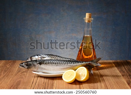 Fresh fish mackerel, lemon and wine in the bottle on the table