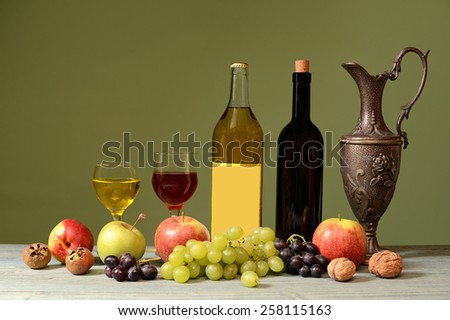 Fresh fruits, wine and metal carafe on the table