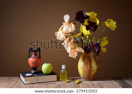 Yellow irises, amphorae, apple and book on the table