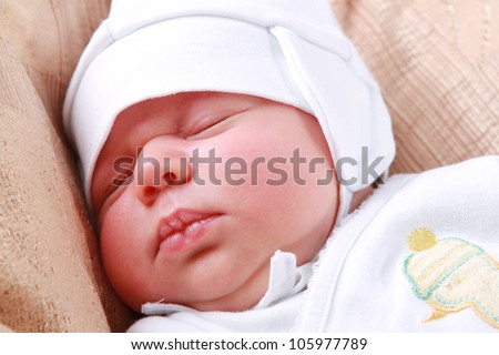 sleeping caucasian baby boy over light beige textured