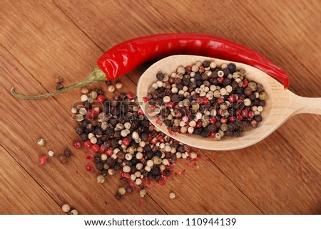 red hot chilli and some ground peppers over brown wooden background/agriculture objects
