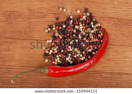 agriculture objects (red hot chilli and some ground peppers) over brown wooden background/organic paprika