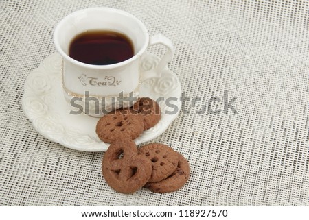 Top view o ivory cup of tea with cookies on Food and Drink theme/Image of black tea cup with yummy biscuits