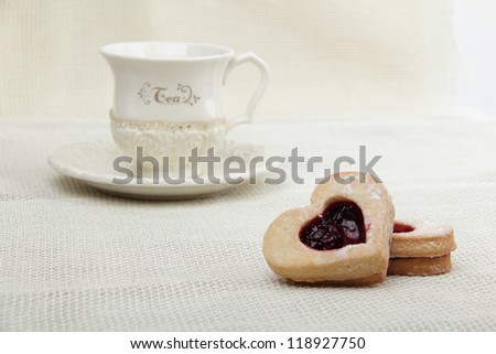 Ivory cup of tea with heart symbol cookies in focus on Food and Drink theme