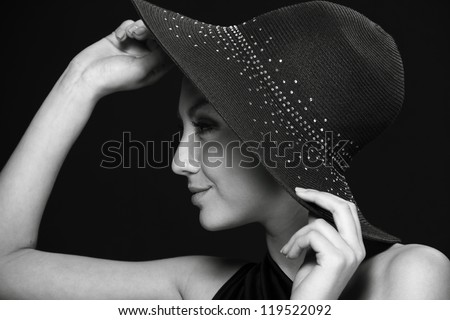 Close up portrait of lovely black dress and black hat over dark background on Beauty and Fashion theme