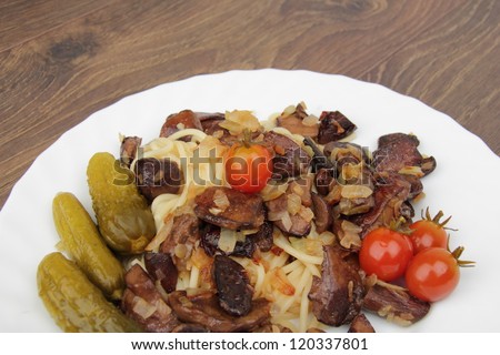 White plate with pasta with mushrooms and small tasty tomatoes on Food and Drink theme/Vegetarian dish as a pasta and mushrooms