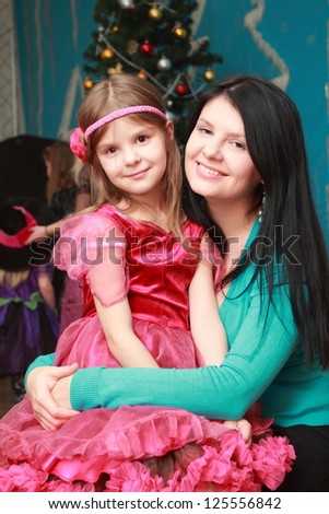 Smiley mother and daughter over decorative christmas background