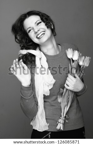 Black and white image of young cheerful european woman with tulips/Beautiful young girl with a bouquet of spring flowers