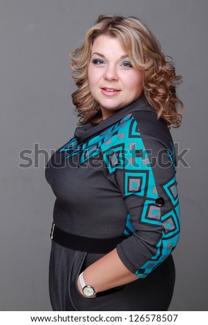 Pretty face of european woman as a plus size mode/Caucasian woman wearing elegant blue and gray dress on Beauty and Fashion theme