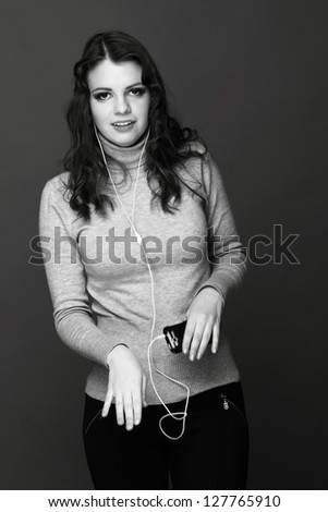 Black and White portrait of trendy teenage listening music by headphones