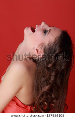 Sexy woman wearing red dress over bright red background on Beauty and Fashion theme