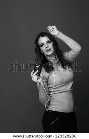 Black and White portrait of young woman dancing to music with headphones/Girl in headphones listens to music
