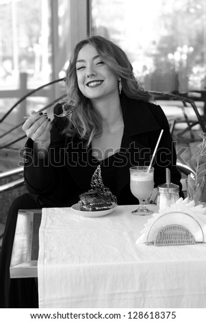 Black and white portrait girl at street cafe/Smiley attractive young woman in street cafe on Food and Drink theme