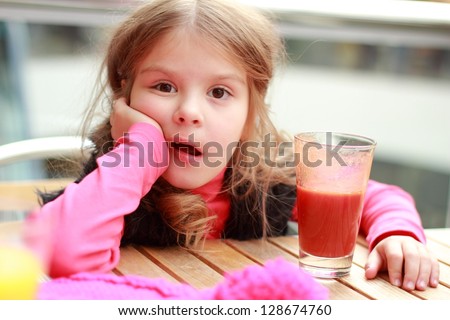 Cute girl drinks  juice in cafe/Funny child at cafe indoor