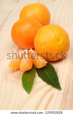 Lots of tangerine on a light wooden table/Organic mandarin whole and slices