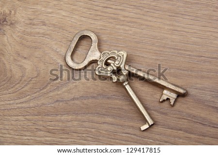 Old keys on wooden table, close up photo/Old metallic keys on a wooden background
