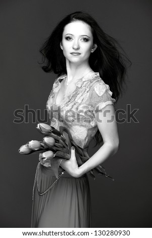 Black and white image of a beautiful young woman with long healthy hair in a beautiful dress