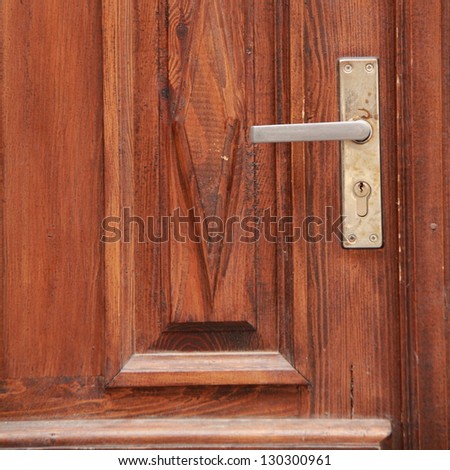 Wooden door with light wood with a metal lock and handle