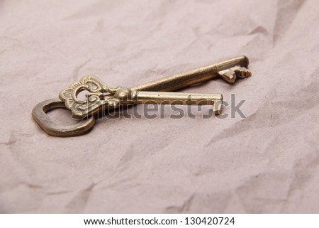 Two antique keys lies on a background of crumpled paper