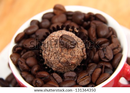 raw coffee beans and chocolate in red coffee cup
