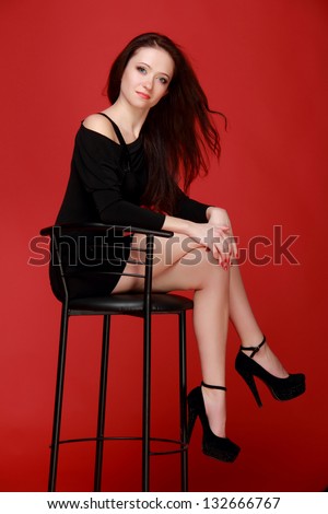 Nice woman with dark hair sitting in a high chair on Beauty and Fashion