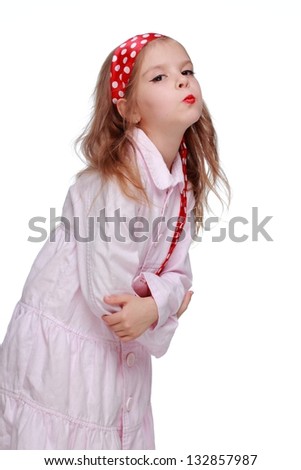 Positive emotional little girl with brightly painted lips in white dress