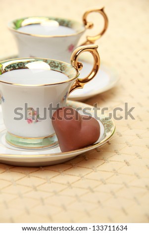 Classic coffee cup  chocolate candy on the beige tablecloth on Food and Drink