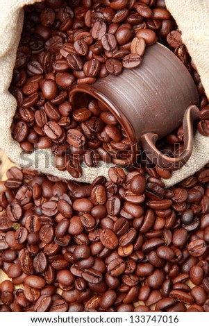 dark brown coffee cup over beige burlap  coffee bag